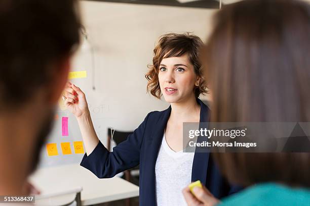 businesswoman giving presentation - apresentar imagens e fotografias de stock