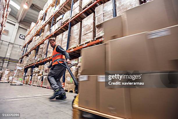 motion blur of a man moving boxes in a warehouse - pallet industrial equipment 個照片及圖片檔