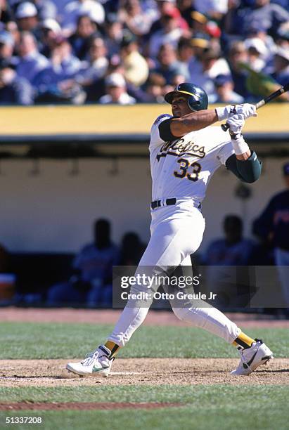 Jose Canseco of the Oakland Athletics watches the flight of the ball as he follows through on a swing during a game against the Cleveland Indians at...