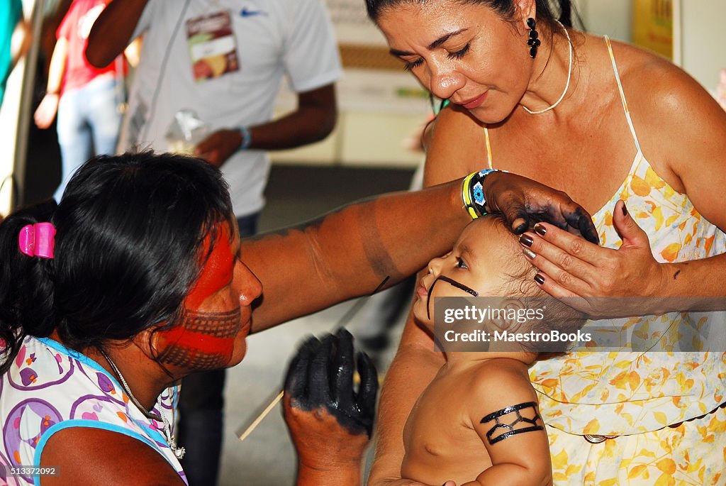 Child being painted by Amazonian Indian .