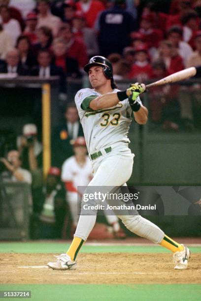 Jose Canseco of the Oakland Athletics watches the flight of the ball as he follows through on a swing during Game Two of the 1990 World Series...