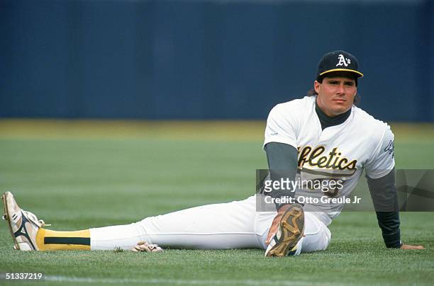 Jose Canseco of the Oakland Athletics stretches on the field prior to a 1991 MLB season game at Oakland-Alameda County Coliseum in Oakland,...