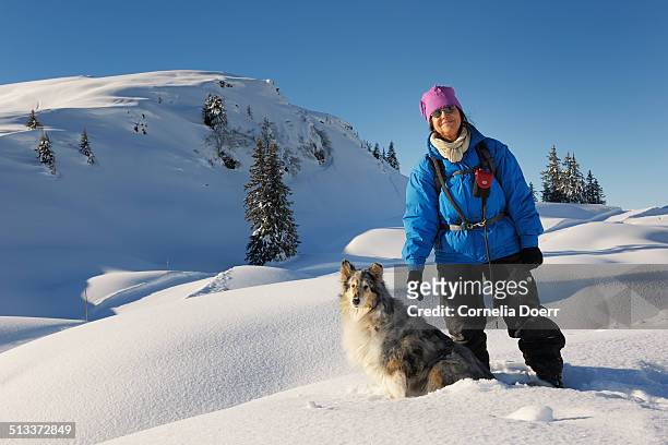 woman enjoying winter day with her dog - sonnenkopf stock pictures, royalty-free photos & images