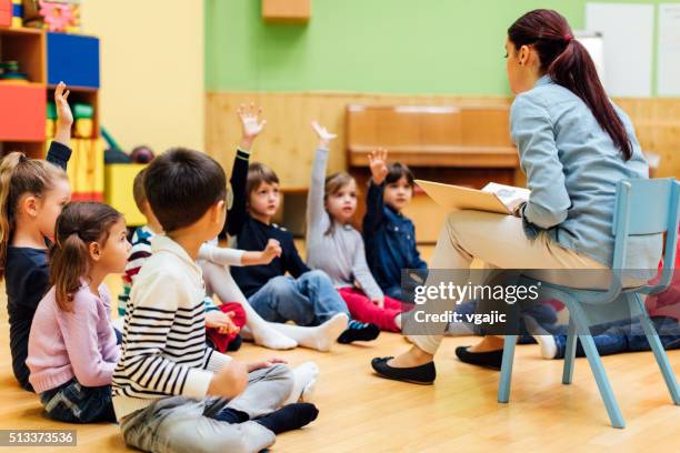 professeur questionnement les enfants d'âge préscolaire en salle de classe. - ecole-maternelle photos et images de collection
