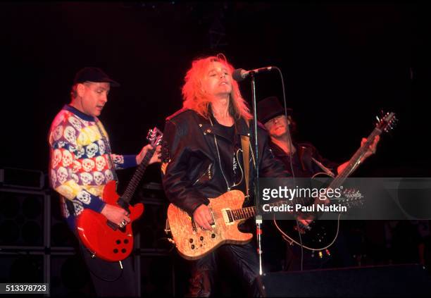 American musicians Rick Nielsen , Robin Zander , of the band Cheap Trick, perform with an unidentified, third guitarist at the Riviera Theater,...