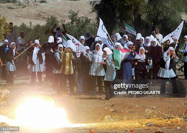 Stun grenade is fired by Israeli border police at Palestinian schoolgirls demonstrating against the construction of the Israeli separation barrier in...