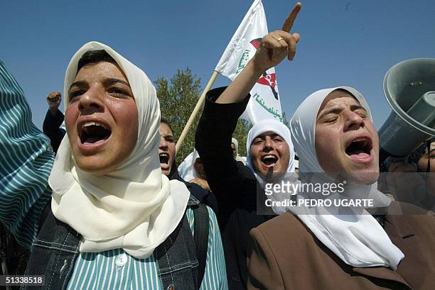 Palestinian schoolgirls chant slogans during a demonstration against the construction of the Israeli separation barrier in the southern West Bank...