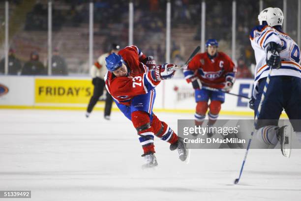 Forward Michael Ryder of the Montreal Canadiens shoots while being defended by Steve Staios of the Edmonton Oilers during the game at the Molson...