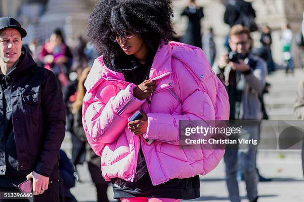 Julia Sarr Jamois wearing a huge pink feather down jacket and a black hoody outside Maison Margiela during the Paris Fashion Week Womenswear...