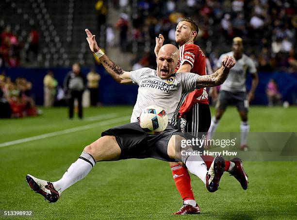 Jelle Van Damme of the Los Angeles Galaxy loses his footing as he defends against Paul Arriola of Club Tijuana during the first half at StubHub...