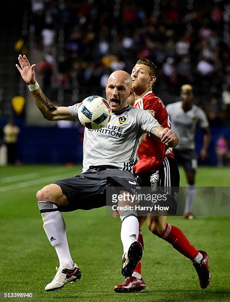 Jelle Van Damme of the Los Angeles Galaxy loses his footing as he defends against Paul Arriola of Club Tijuana during the first half at StubHub...