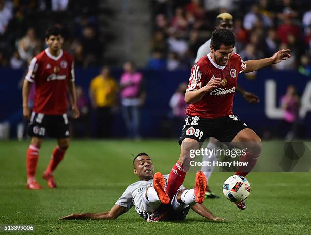 Ashley Cole of the Los Angeles Galaxy attempts to kick the ball from Hiram Munoz of Club Tijuana during the first half at StubHub Center on February...