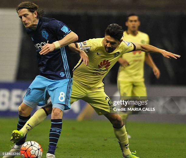 Forward Oribe Peralta of Mexican club America vies for the ball with Erick Friberg of US Seattle Sounders during their CONCACAF Champions League...