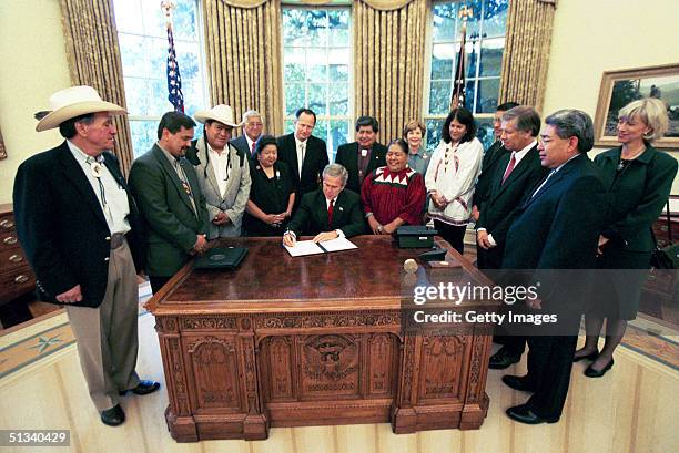 Seen in this handout photo, President George W. Bush signs the Executive Memorandum on Tribal Sovereignty and Consultation in honor of the opening of...