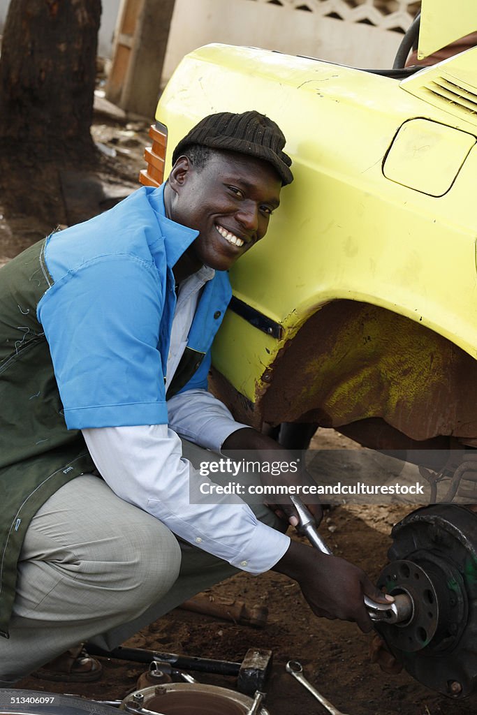 A smiling mechanic repairing a wheel