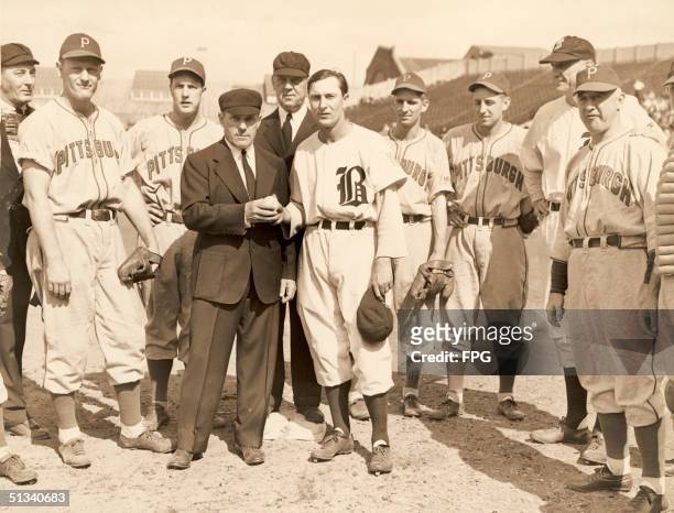 Chief umpire Bill Stewart presents a ball to Boston Braves baseball player Paul Waner , who made his 3,000th career hit in a match against the...