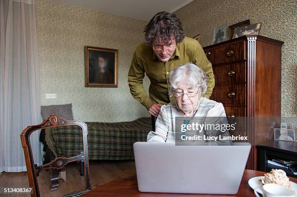senior woman and mature man with laptop - achterdeur stockfoto's en -beelden