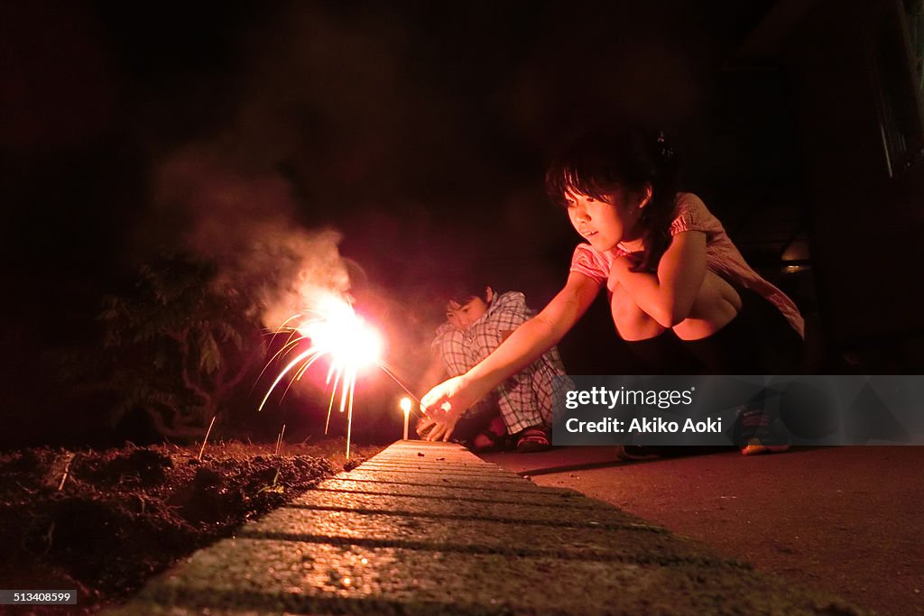 Boy and girl playing with fireworks