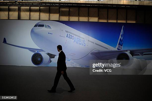 Man walks past a poster of an Airbus A330 aircraft at the Tianjin Airport Economic Area on March 2, 2016 in Tianjin, China. As the first Completion...
