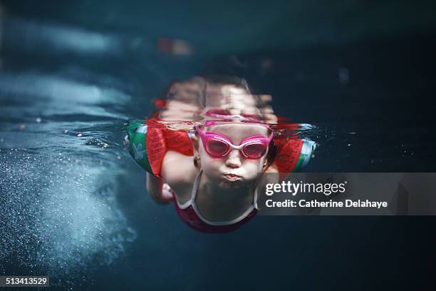 a 4 years old girl swimming under water - children swimming photos et images de collection