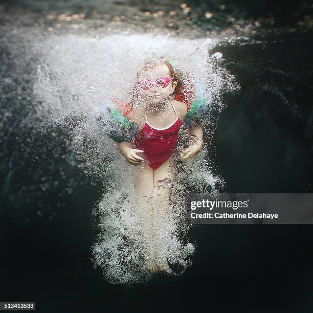 a 4 years old girl plunging in a swimming pool - underwater photography through the years stockfoto's en -beelden