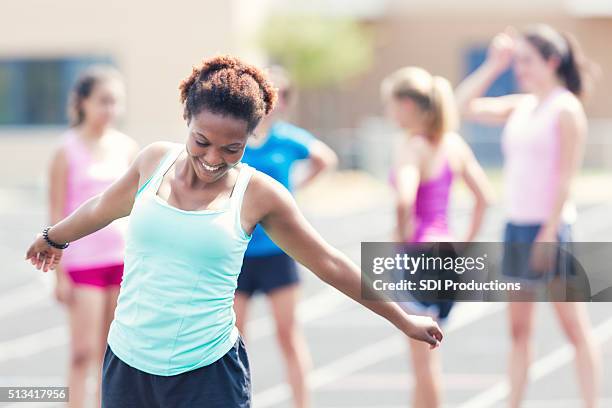 high school athlete stretches as she prepares for race - girls on train track stock pictures, royalty-free photos & images