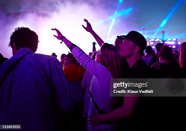 young couple watching outside concert at night - couple concert photos et images de collection