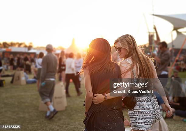 girlfriends walking together at big festival - music festival grass stock pictures, royalty-free photos & images