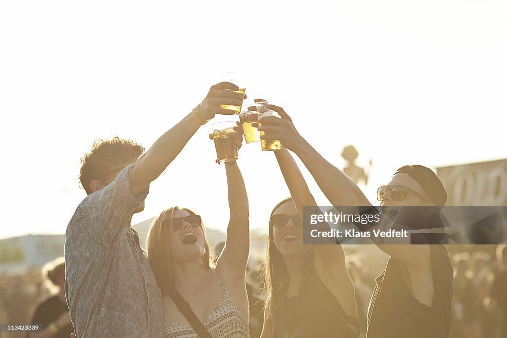 Friend toasting in beer at outside festival