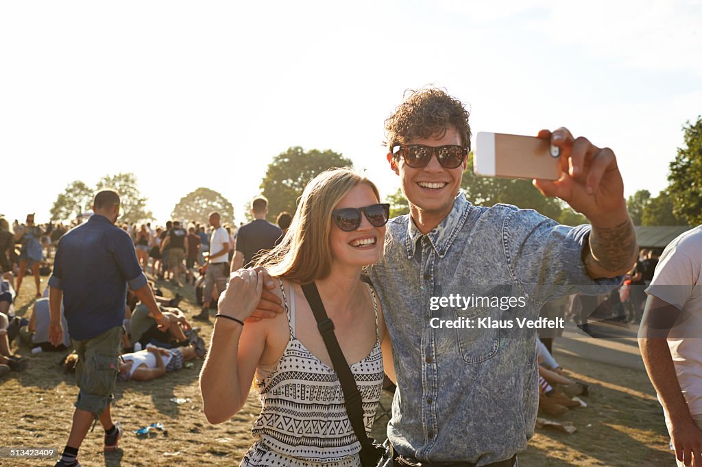 Young couple making selfie at music festival