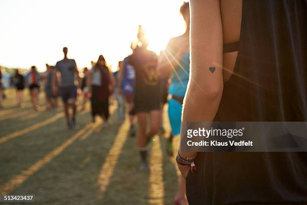 female arm with festival bands & heart tattoo - tatouage femme photos et images de collection