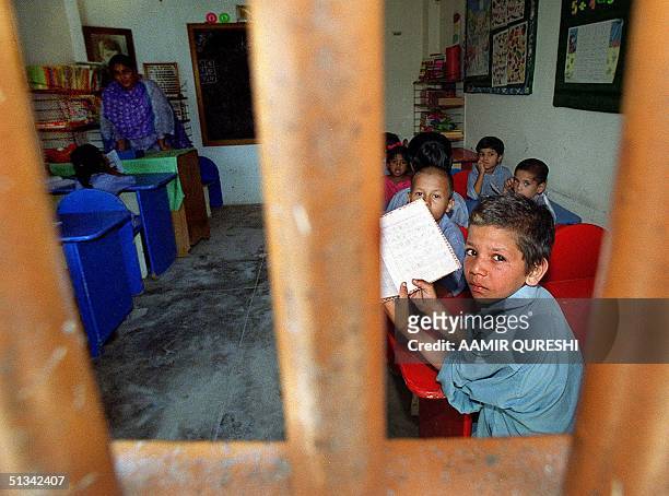 Pakistani children study in school inside a central pirson in southern Karachi, 14 May 2001 where they grown-up with their imprisoned mothers. Some...