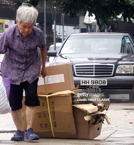 This file picture dated 03 September 2001 shows an elderly Hong Kong resident dragging cardboard boxes for recycling along a street in Hong Kong....