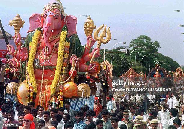 Residents take part in a procession as idols of the Hindu elephant-headed god Lord Ganesh are taken to the seaside before being lowered into the sea...