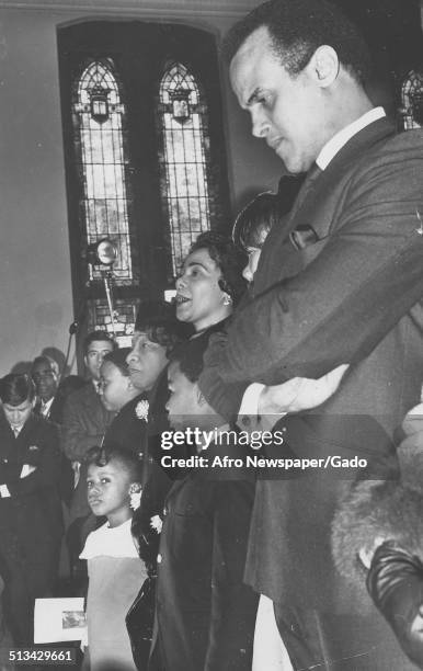 Civil Rights leader Coretta Scott King, Dexter Scott King, Yolanda King, Bernice Albertine King, and Harry Belafonte singing in a church during a...