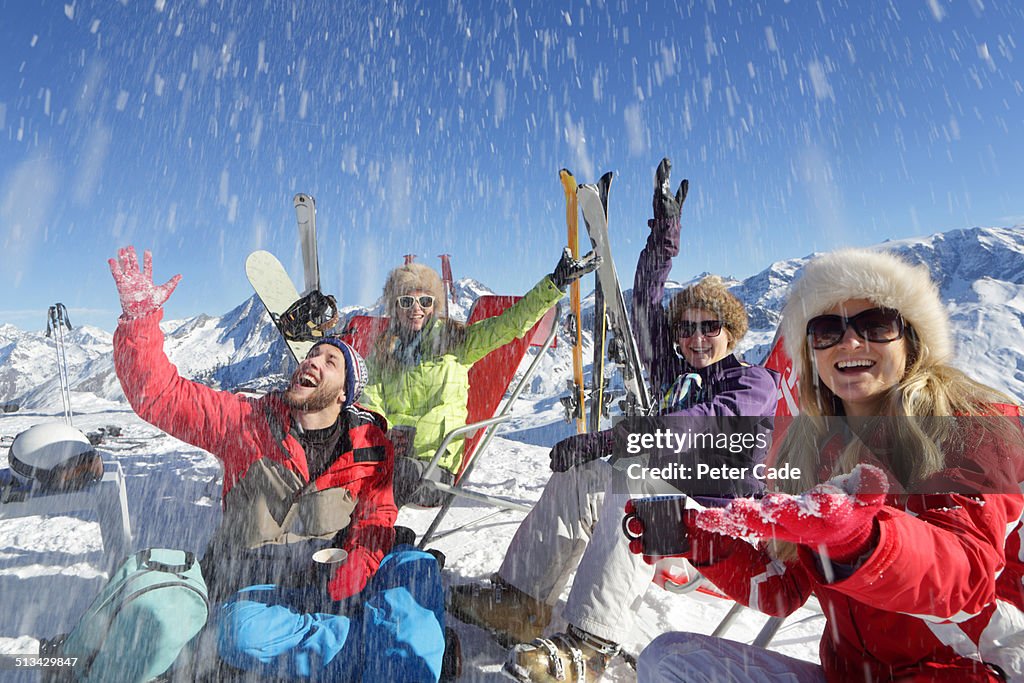 Four young adults relaxing on ski slope