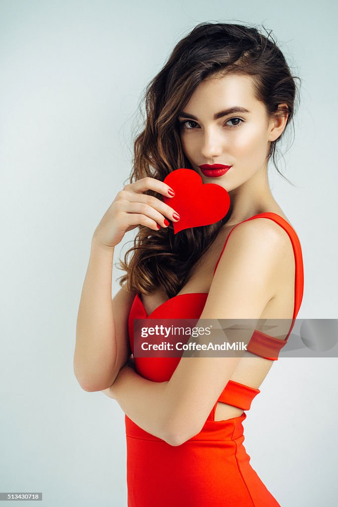 Beautiful girl holding artificial heart