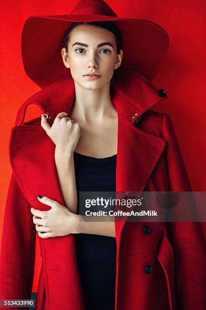 beautiful girl with make-up wearing red coat and hat - red coat stock pictures, royalty-free photos & images