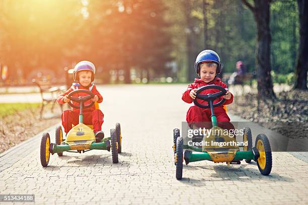 little boys racing on pedal go-karts - bike pedal stock pictures, royalty-free photos & images