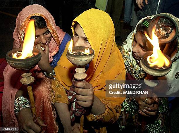 Pakistani girls carry torches during a procession to observe the Women Day in Islamabad, 08 March 2001. The national Women's week began here today,...