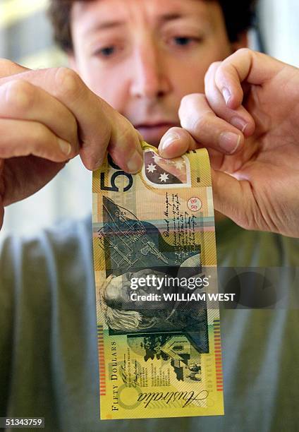 Sydneysider Martin Parry tries unsuccessfully to tear an Australian 50 dollar note which is made of polymer, a durabile, clean and secure banknote...