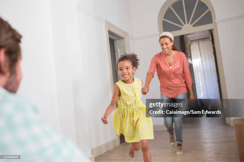 Mother and daughter running towards father