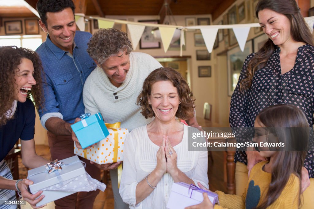 Older woman being given gift by family