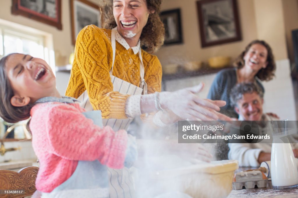 Mutter und Tochter spielen mit Mehl in der Küche