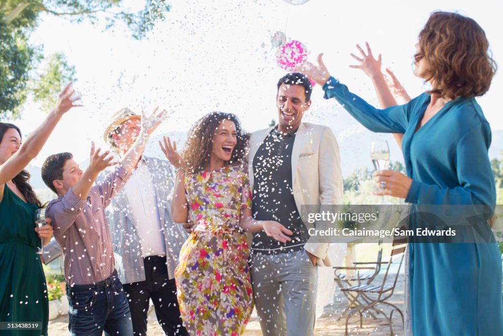 Family throwing confetti on newlywed couple