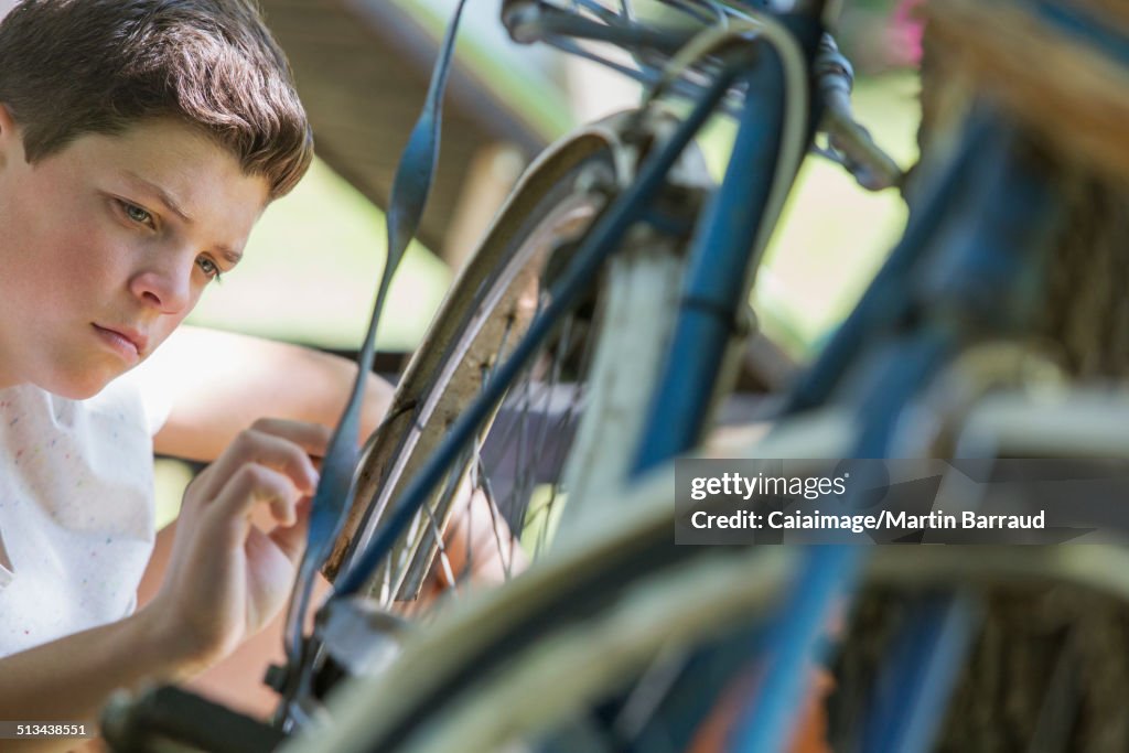 Young boy examining bicycle outdoors