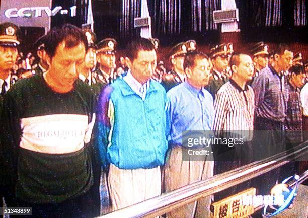 In this frame taken off China's state television, officials arrested on corruption charges stand at attention in a Chinese court of law 08 November...