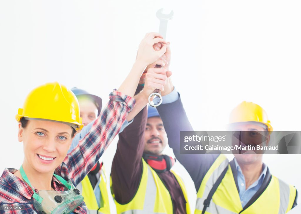 Portrait of construction workers joining hands