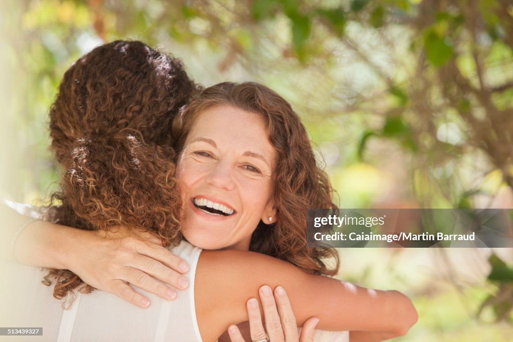 Madre e figlia che si abbracciano all'aperto