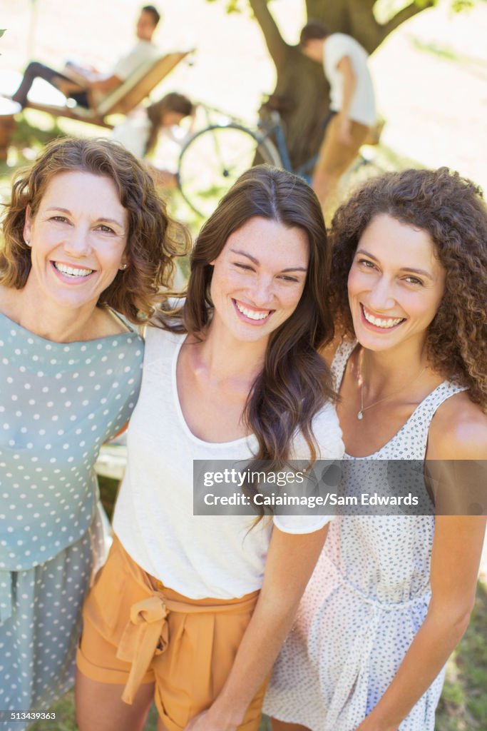 Mother and daughters hugging outdoors